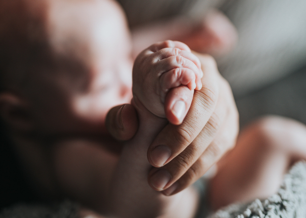 Tiny fingers Holing on to Adult Hand