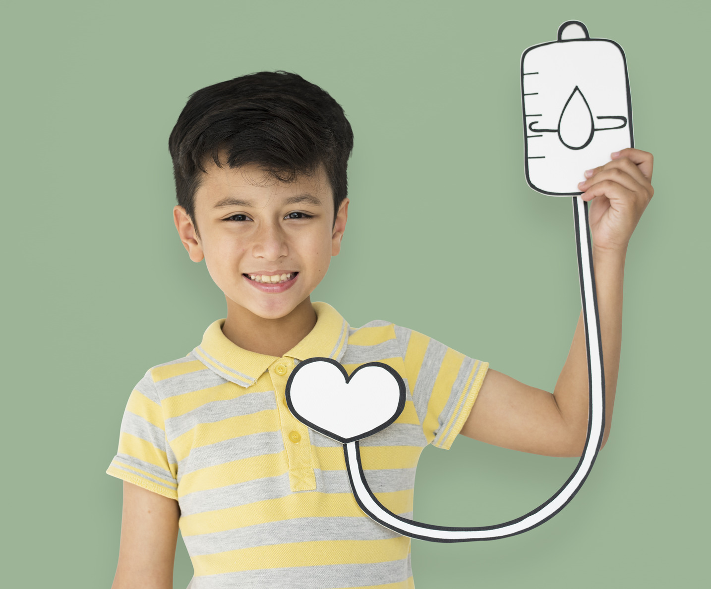 Young boy holding an illustrated blood bag to simulate blood transfusion for sickle cell anaemia